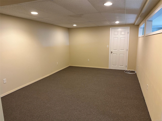 carpeted spare room with a drop ceiling