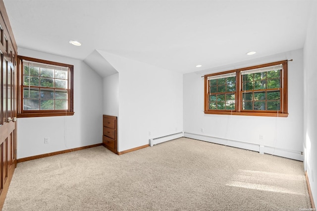 additional living space with baseboard heating and light colored carpet