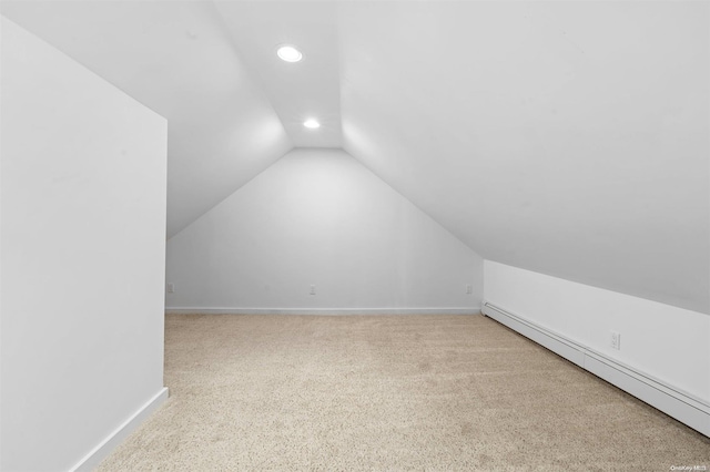 additional living space featuring carpet flooring, a baseboard radiator, and lofted ceiling