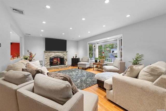 living room with a fireplace and light wood-type flooring