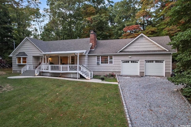 ranch-style house featuring a porch, a garage, and a front yard