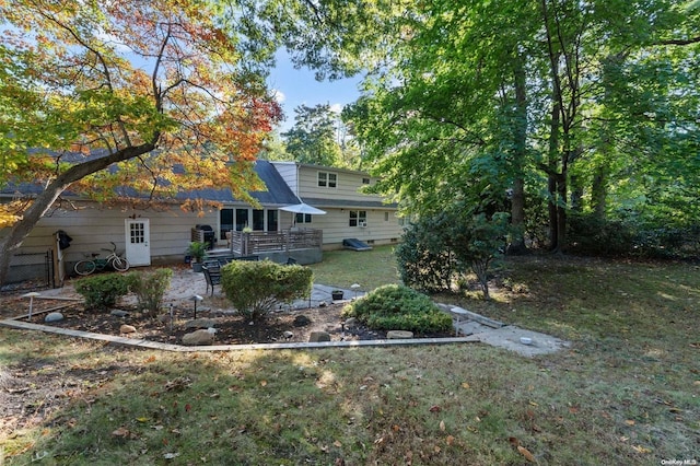 back of property with a yard and a patio area