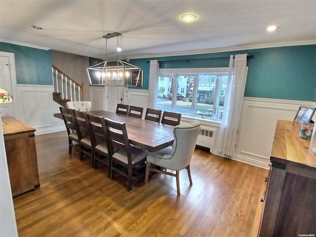 dining area featuring a chandelier, radiator heating unit, dark wood-type flooring, and ornamental molding