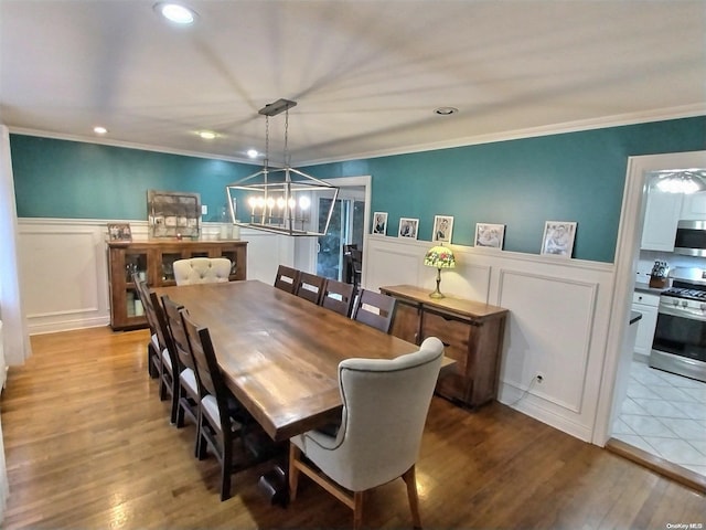 dining room featuring light hardwood / wood-style floors, crown molding, and an inviting chandelier