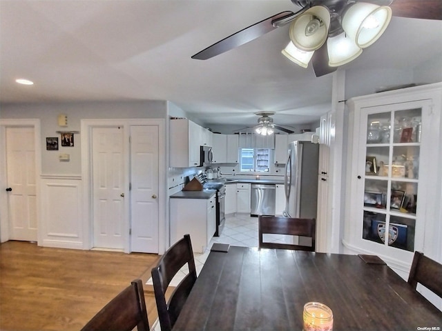 dining space with ceiling fan and light wood-type flooring