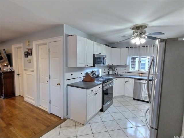 kitchen with ceiling fan, white cabinetry, stainless steel appliances, and light hardwood / wood-style flooring