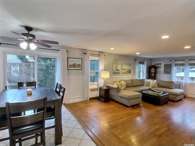 living room featuring light hardwood / wood-style flooring, radiator, and ceiling fan