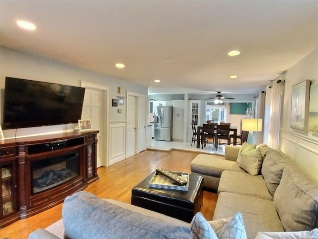 living room with ceiling fan and light wood-type flooring