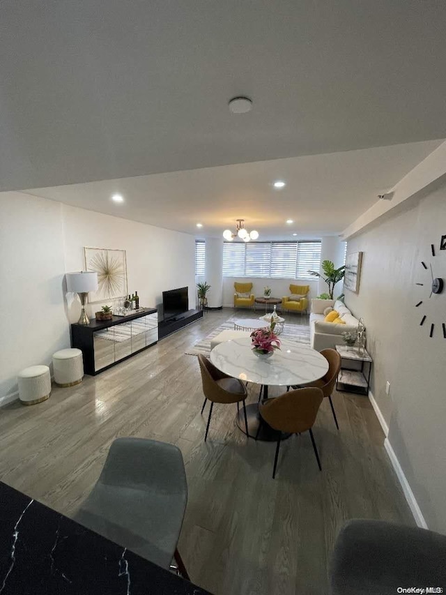 dining space with wood-type flooring and a chandelier