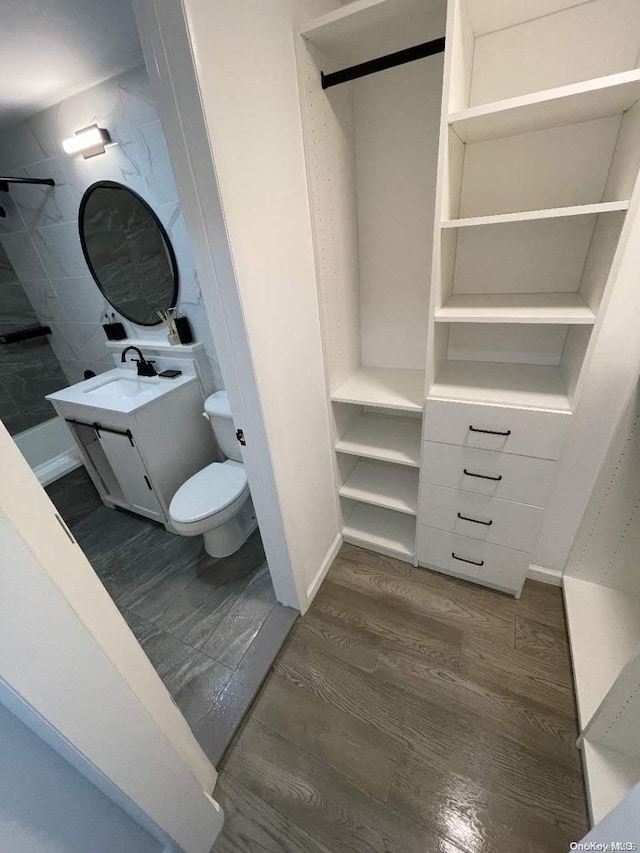 bathroom with hardwood / wood-style floors, vanity, and toilet