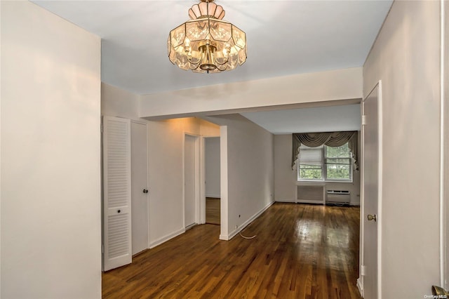 hallway with dark hardwood / wood-style floors and an inviting chandelier