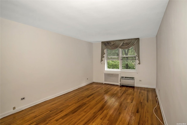 unfurnished room featuring dark hardwood / wood-style flooring and radiator