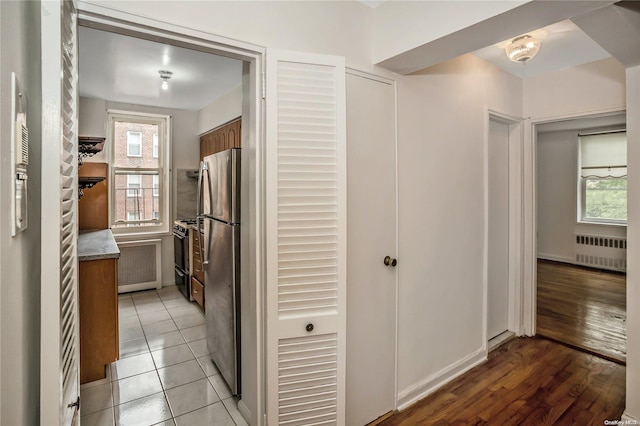 corridor featuring radiator heating unit and light tile patterned floors