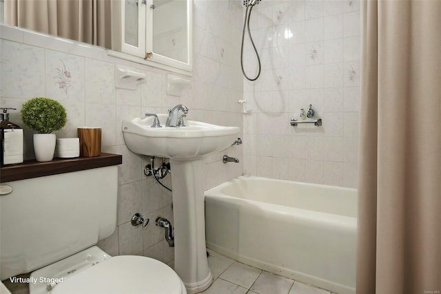 bathroom with tile patterned flooring, shower / bathtub combination with curtain, toilet, and tile walls