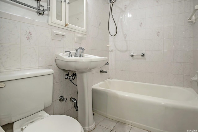 bathroom with tile patterned flooring, shower / bath combination, toilet, and tile walls