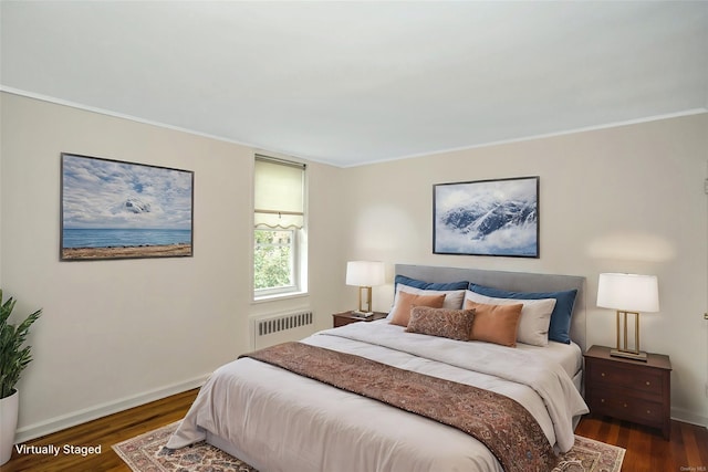 bedroom with radiator heating unit, dark hardwood / wood-style flooring, and ornamental molding