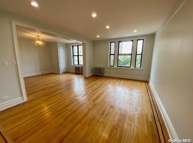 unfurnished room with light hardwood / wood-style floors and an inviting chandelier