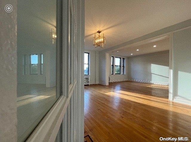 unfurnished room featuring hardwood / wood-style floors and a notable chandelier