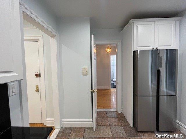 kitchen with white cabinets and stainless steel refrigerator