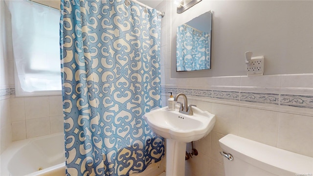 bathroom featuring toilet and tile walls