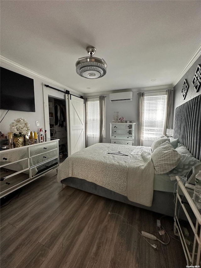 bedroom featuring a barn door, dark hardwood / wood-style floors, a wall mounted AC, crown molding, and a textured ceiling