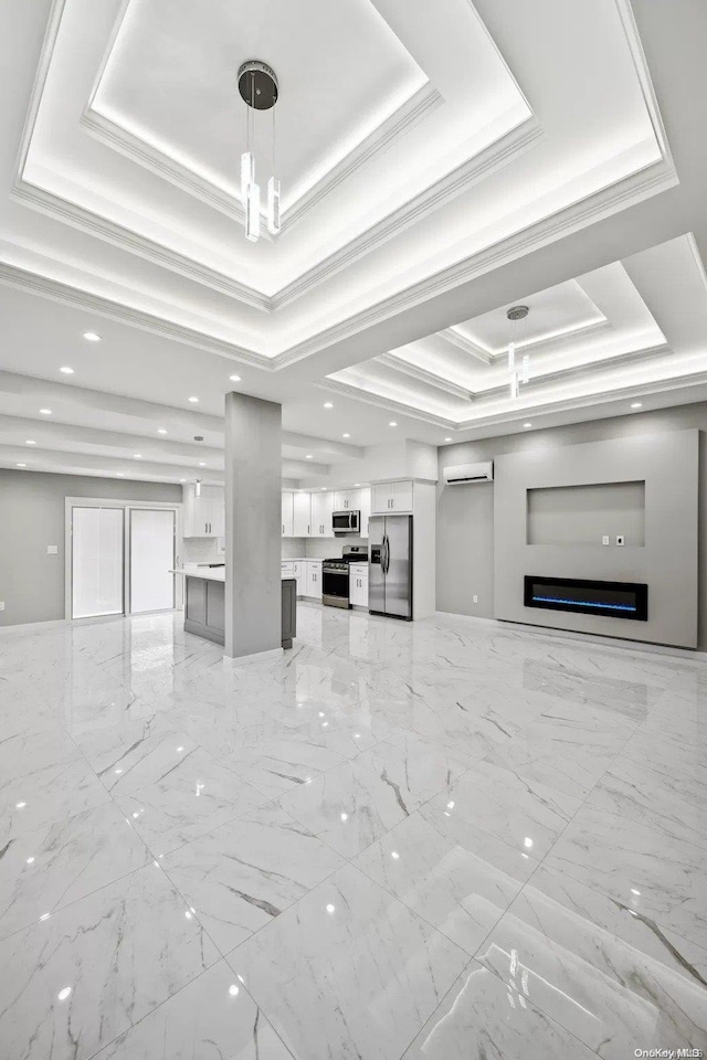 unfurnished living room with ornamental molding, a wall mounted AC, and a tray ceiling