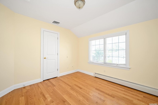 empty room with lofted ceiling, hardwood / wood-style flooring, and baseboard heating