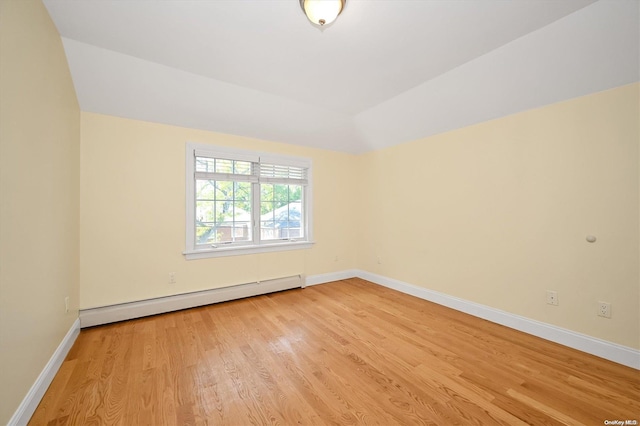 unfurnished room featuring a baseboard radiator and light wood-type flooring