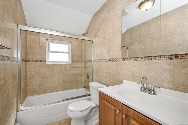 full bathroom featuring tile walls, bath / shower combo with glass door, vanity, tile patterned floors, and toilet