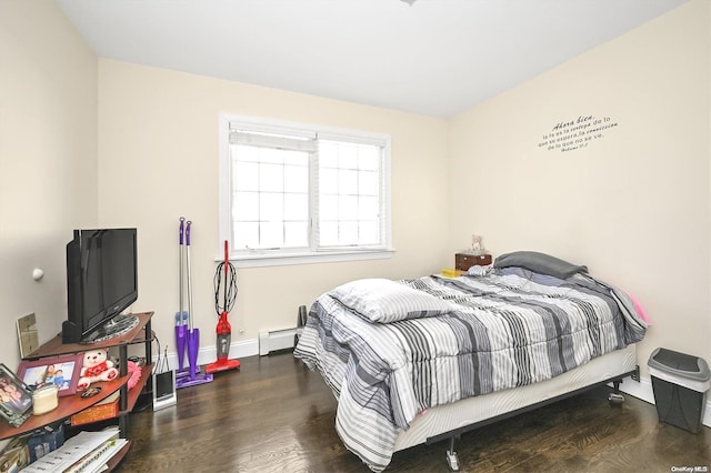 bedroom with a baseboard heating unit and dark wood-type flooring