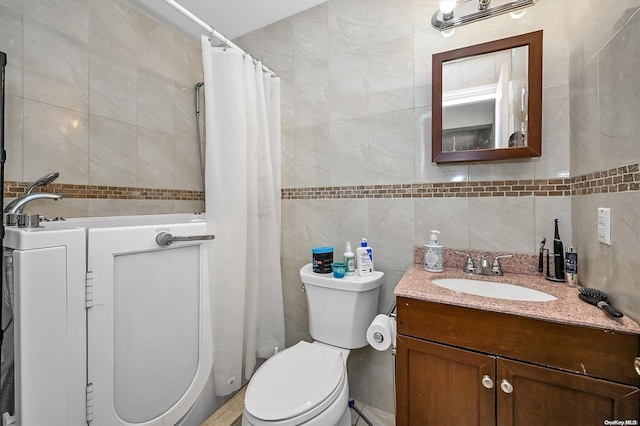 bathroom featuring vanity, tile walls, and toilet