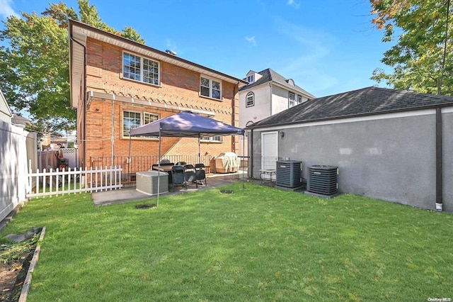 back of property with a patio, cooling unit, and a lawn