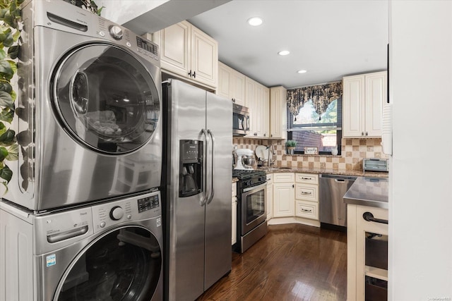 laundry room with dark wood-type flooring and stacked washer / drying machine