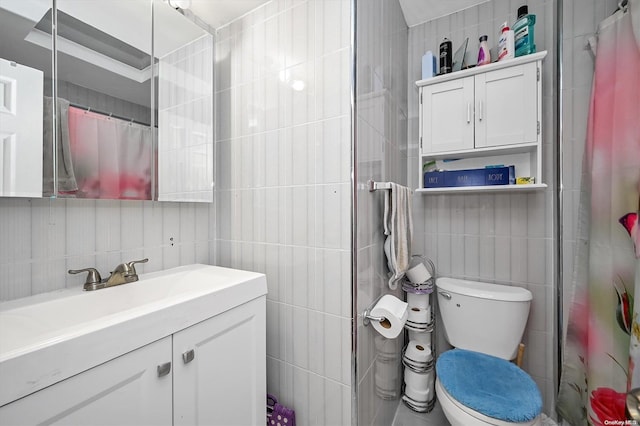 bathroom with a shower with shower curtain, vanity, toilet, and tile walls