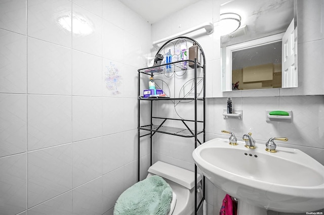 bathroom featuring backsplash, toilet, tile walls, and sink