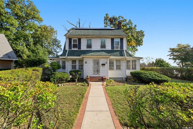 193-32 Foothill Ave, Holliswood, NY 11423 - colonial inspired home with roof mounted solar panels, a chimney, and a shingled roof