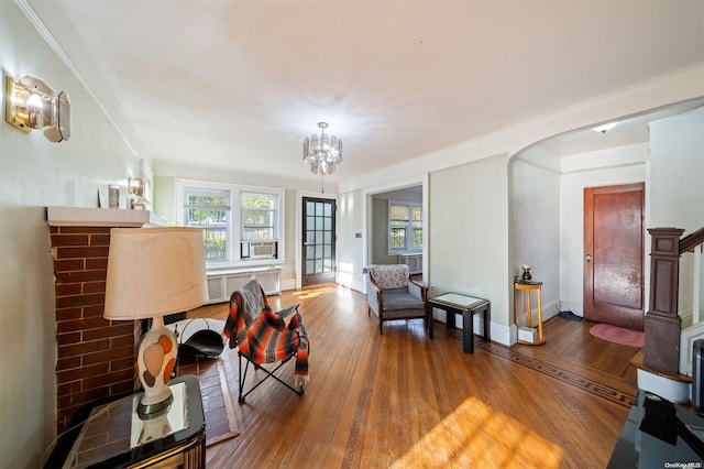 living room featuring hardwood / wood-style flooring, radiator, and a notable chandelier