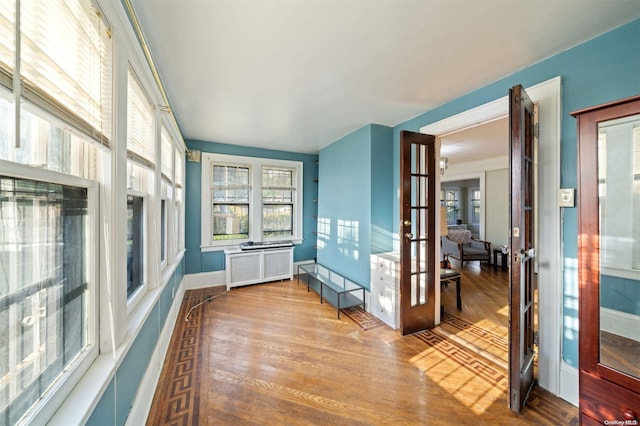 sunroom with french doors and radiator heating unit