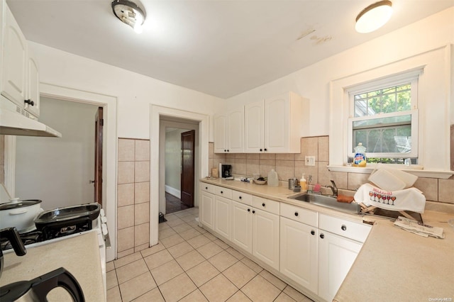 kitchen featuring white cabinetry, sink, light tile patterned floors, and tasteful backsplash