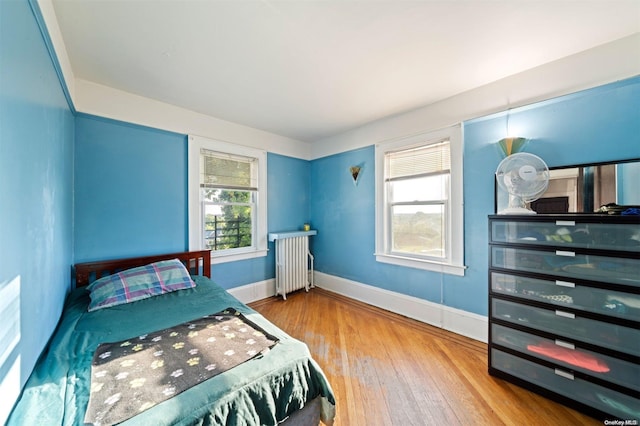 bedroom with radiator and wood-type flooring