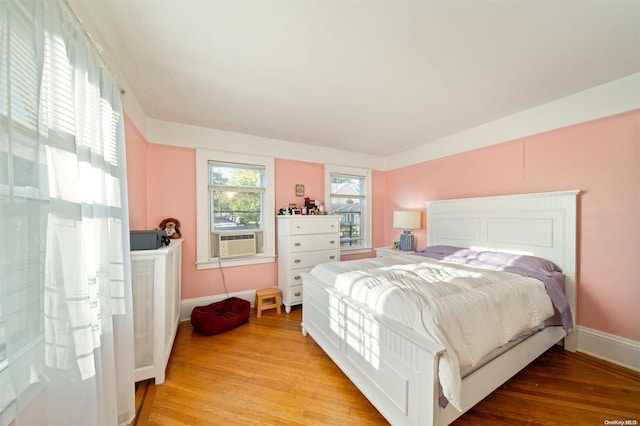 bedroom with light hardwood / wood-style flooring and cooling unit