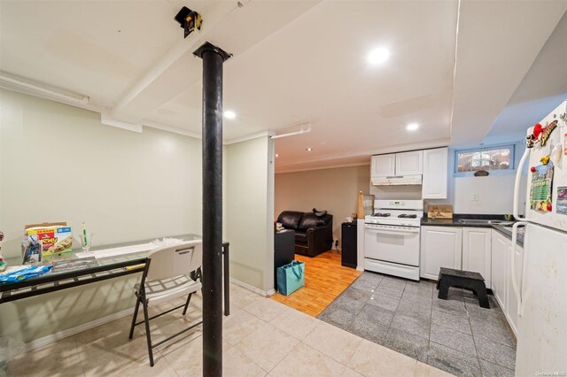 193-32 Foothill Ave, Holliswood, NY 11423 - kitchen featuring white appliances, under cabinet range hood, light tile patterned floors, dark countertops, and white cabinetry