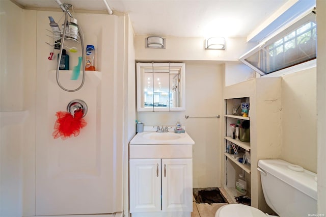 bathroom with a shower, vanity, and toilet