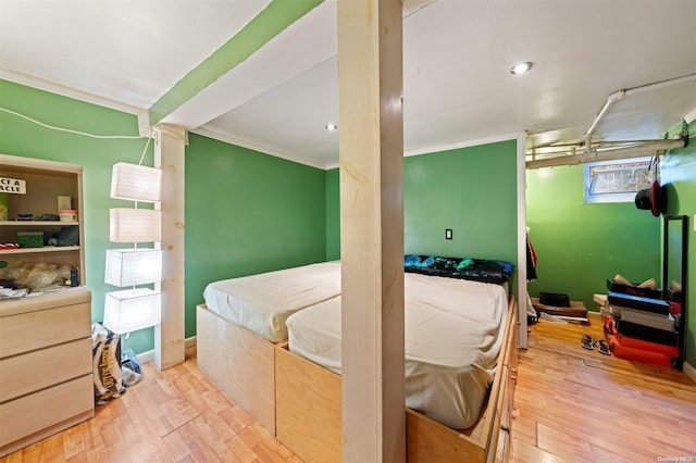 bedroom featuring light hardwood / wood-style flooring and crown molding