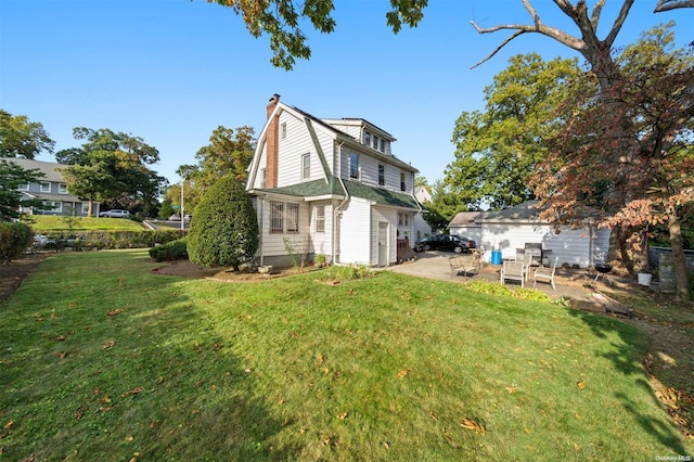 rear view of property featuring a lawn and a patio