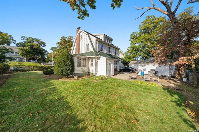 193-32 Foothill Ave, Holliswood, NY 11423 - back of property featuring a chimney, a patio, a yard, and a gambrel roof