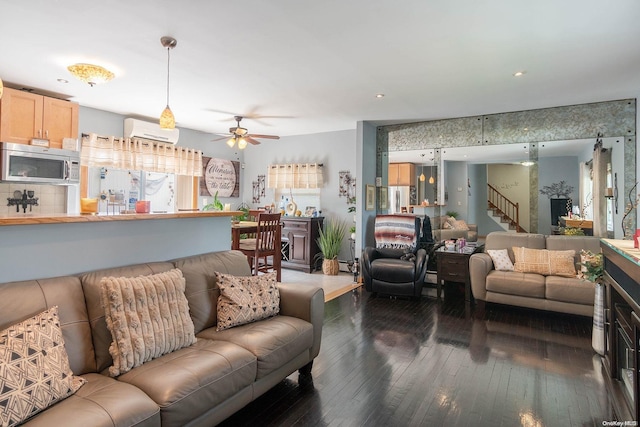 living room with dark hardwood / wood-style floors, a wall unit AC, and ceiling fan