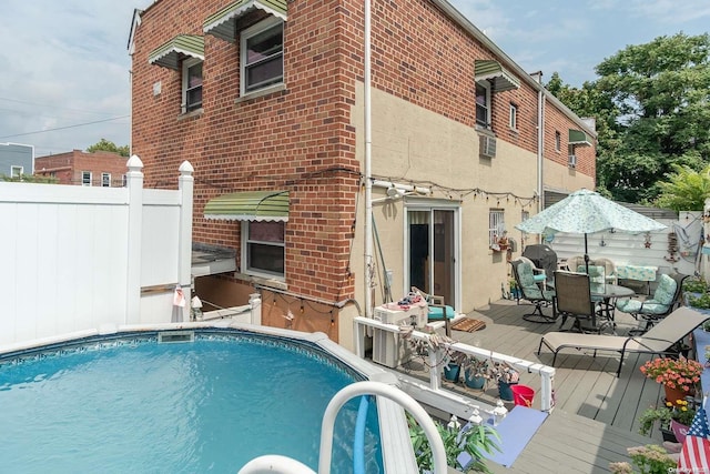 rear view of property featuring a swimming pool side deck