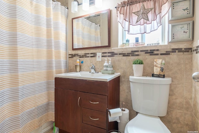 bathroom with vanity, tile walls, and toilet