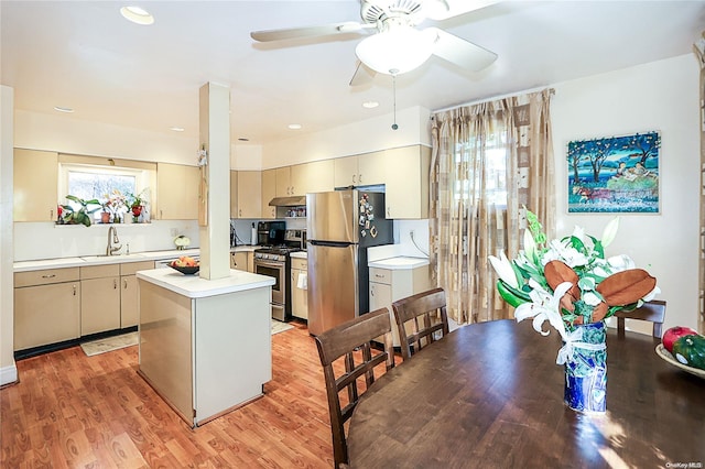 kitchen with cream cabinetry, a kitchen island, light wood-type flooring, and appliances with stainless steel finishes